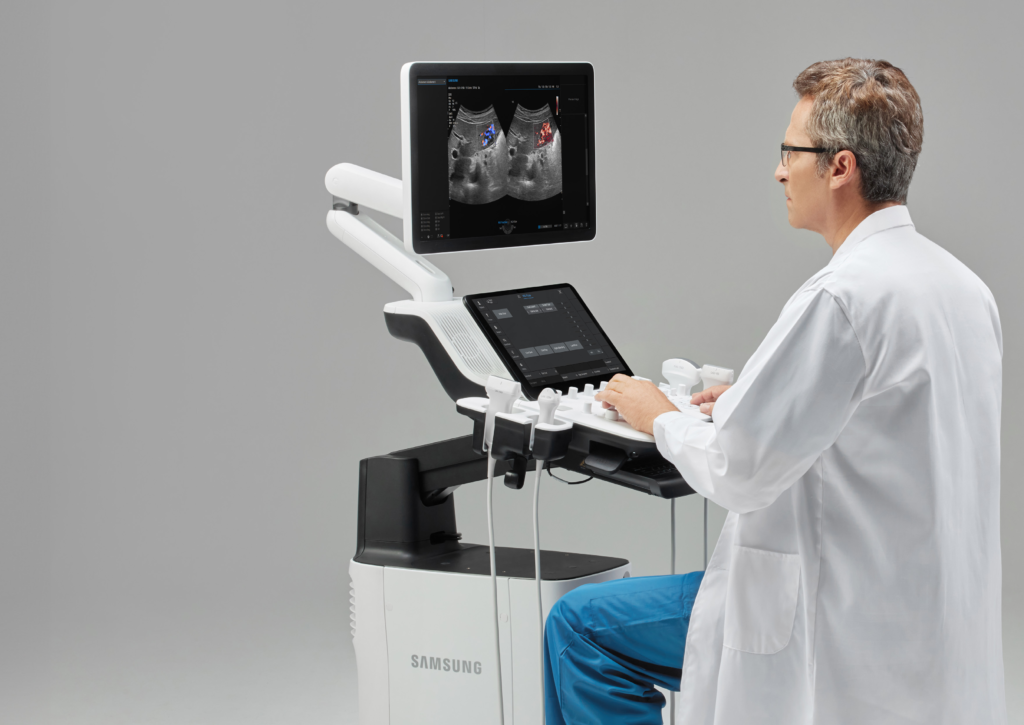 Médecin généraliste utilisant l'échographe Samsung V5 avec sonde convexe ShearWave pour une échographie abdominale